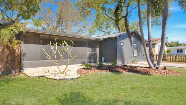 view of front facade featuring a front yard, a sunroom, and fence