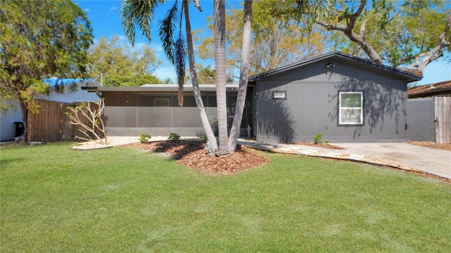 view of front facade featuring a sunroom and a front lawn