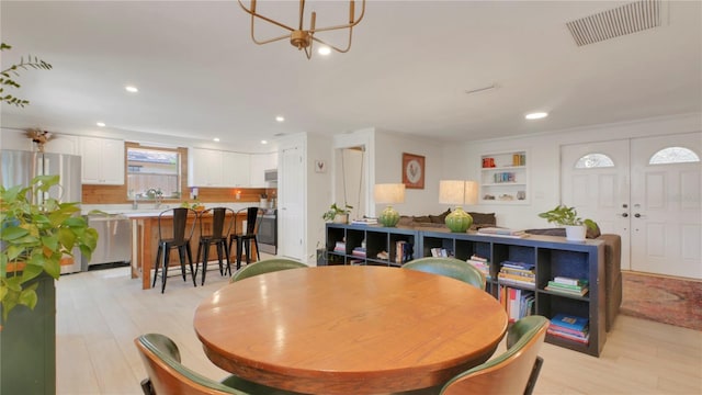 dining area with light wood finished floors, visible vents, a notable chandelier, and recessed lighting