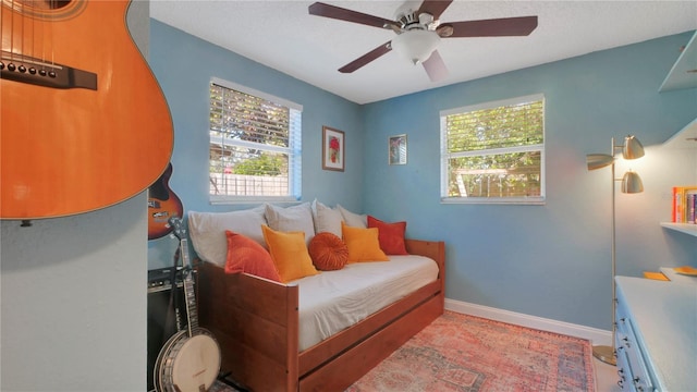 bedroom featuring a ceiling fan and baseboards