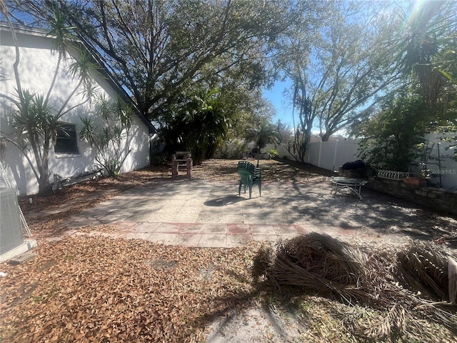 view of yard featuring a patio area, fence, and central AC