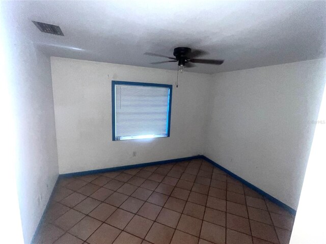 unfurnished room with light tile patterned floors, baseboards, visible vents, and ceiling fan