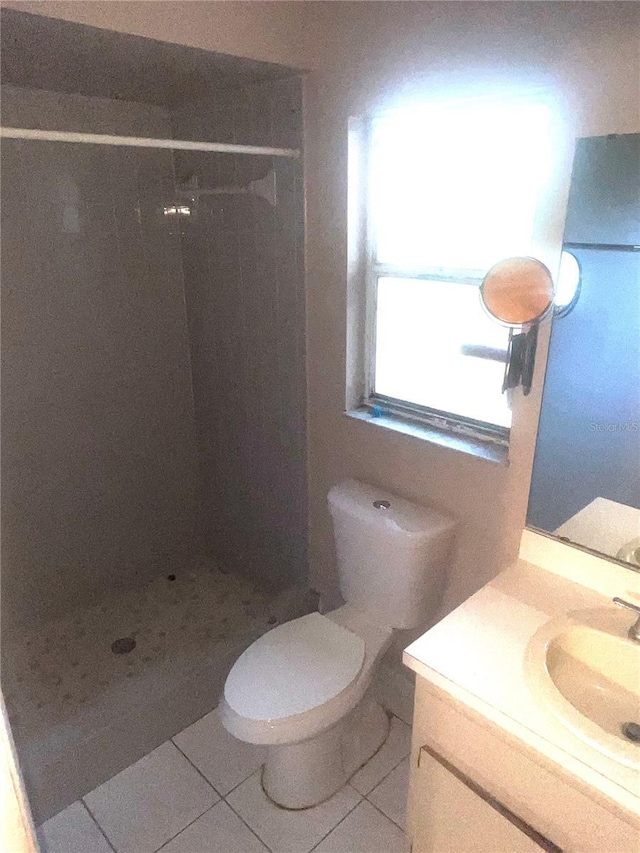 bathroom featuring tile patterned floors, a stall shower, and vanity