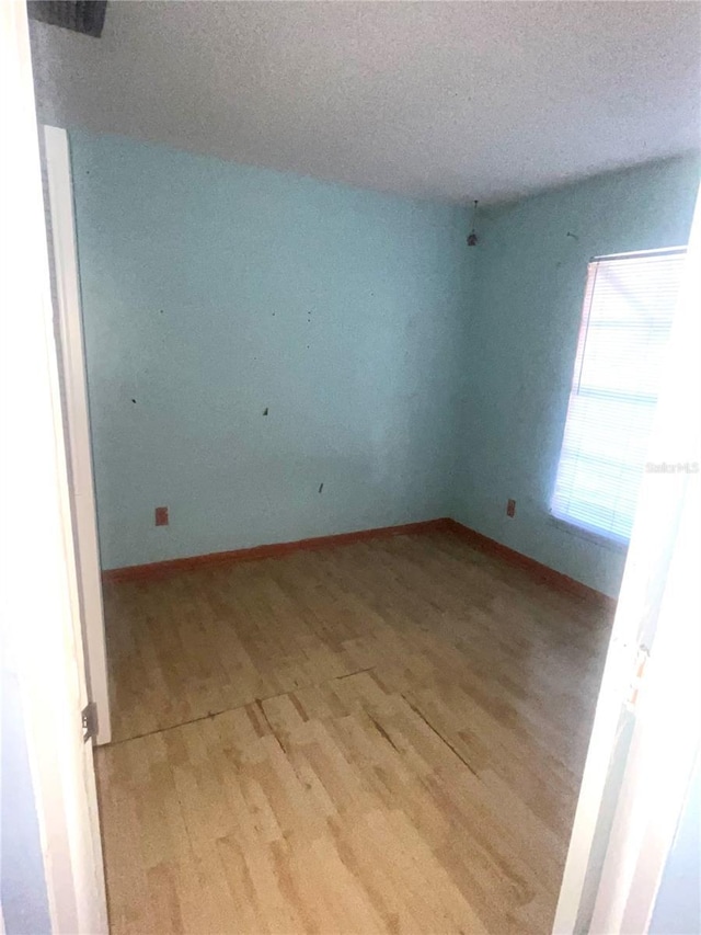 spare room with light wood-type flooring and baseboards