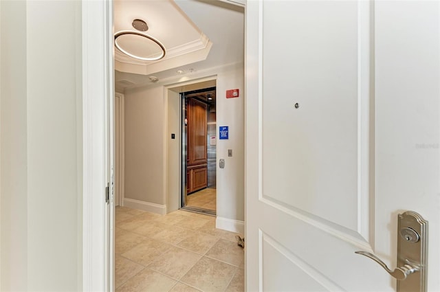 corridor featuring light tile patterned floors and baseboards