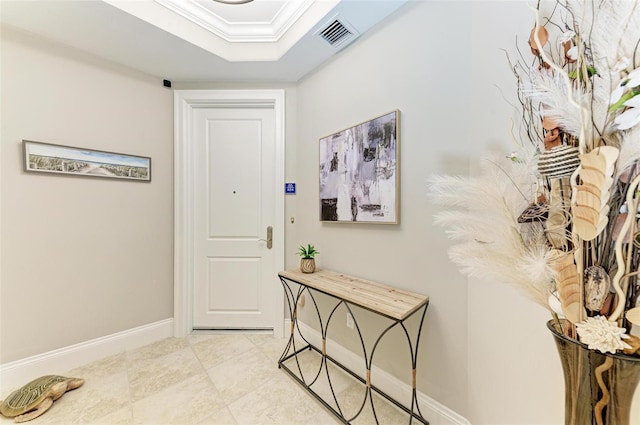 interior space featuring baseboards, visible vents, a tray ceiling, and crown molding