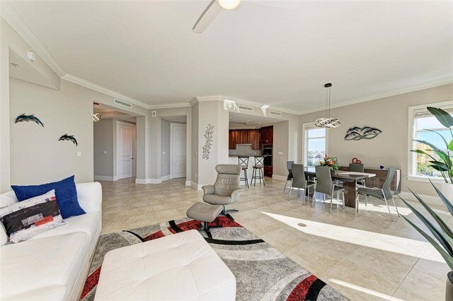 living area with baseboards, plenty of natural light, and crown molding