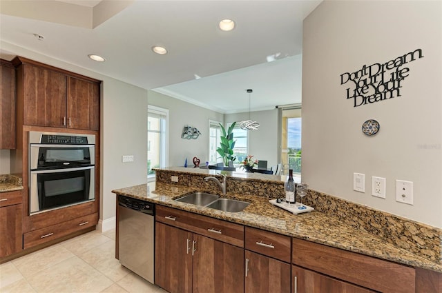 kitchen with light tile patterned floors, stainless steel appliances, a sink, light stone countertops, and a peninsula