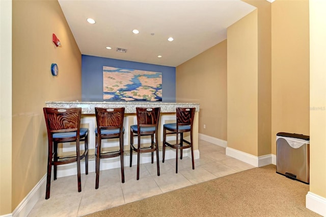 bar featuring baseboards, visible vents, tile patterned flooring, a bar, and recessed lighting