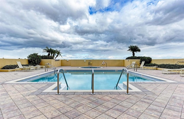 community pool featuring a patio area and a hot tub