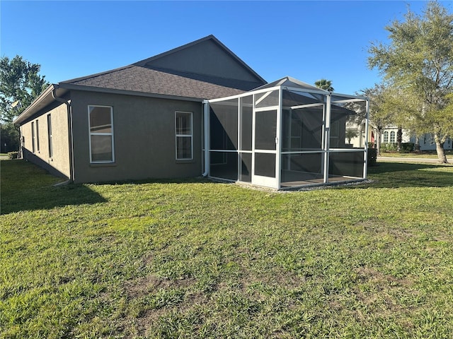 back of property featuring a lanai, a shingled roof, a lawn, and stucco siding