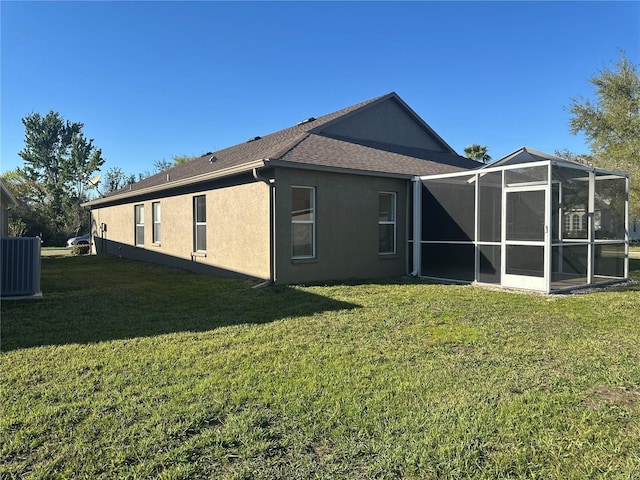 back of house with a shingled roof, a lawn, cooling unit, and stucco siding