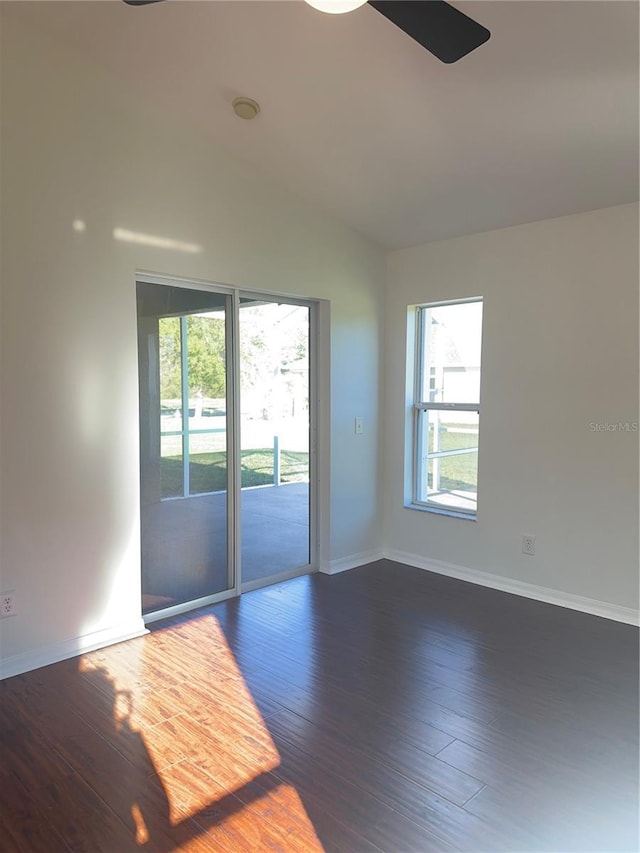 unfurnished room featuring baseboards, vaulted ceiling, and wood finished floors