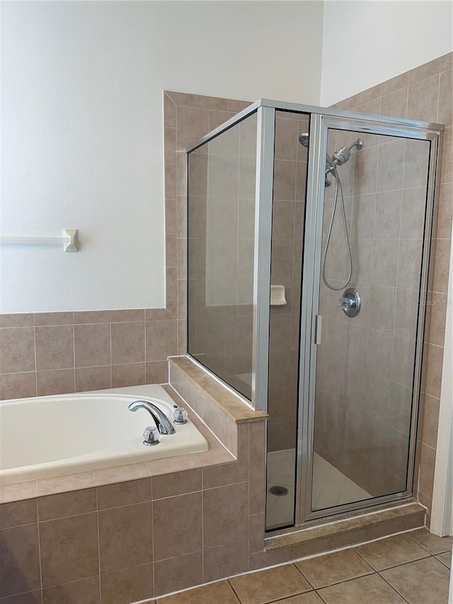 full bath featuring tile patterned flooring, a shower stall, and a bath