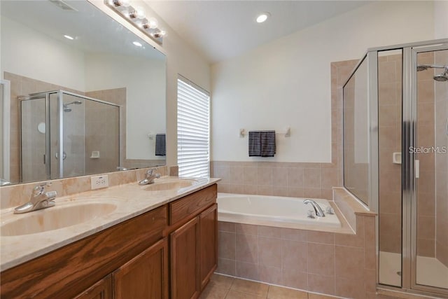 full bathroom featuring a stall shower, a sink, a bath, and tile patterned floors