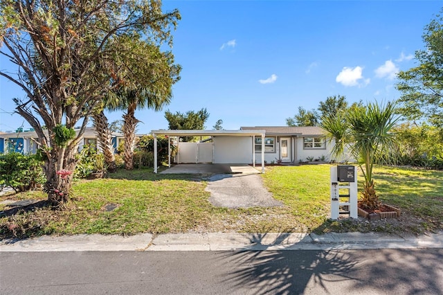 single story home featuring a carport, a front lawn, driveway, and stucco siding