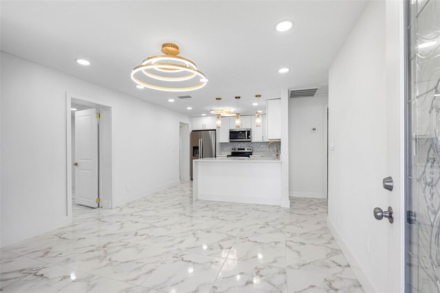 kitchen with white cabinets, appliances with stainless steel finishes, light countertops, backsplash, and recessed lighting