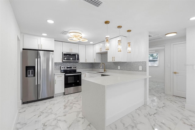 kitchen featuring marble finish floor, appliances with stainless steel finishes, backsplash, and a sink