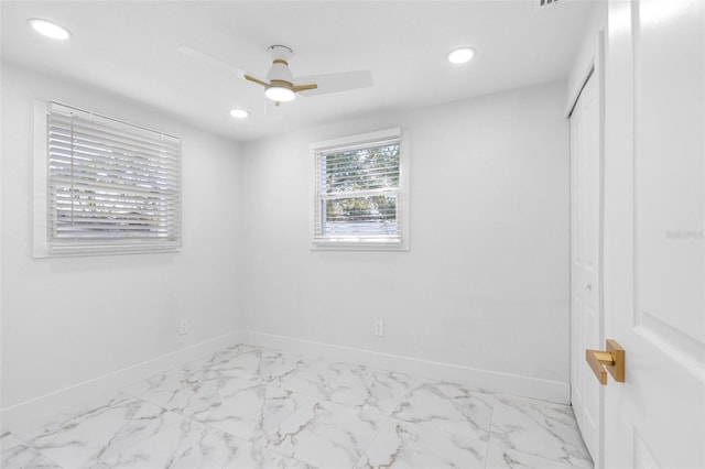 unfurnished bedroom with marble finish floor, baseboards, a closet, and recessed lighting