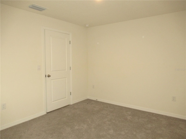 carpeted empty room featuring visible vents and baseboards