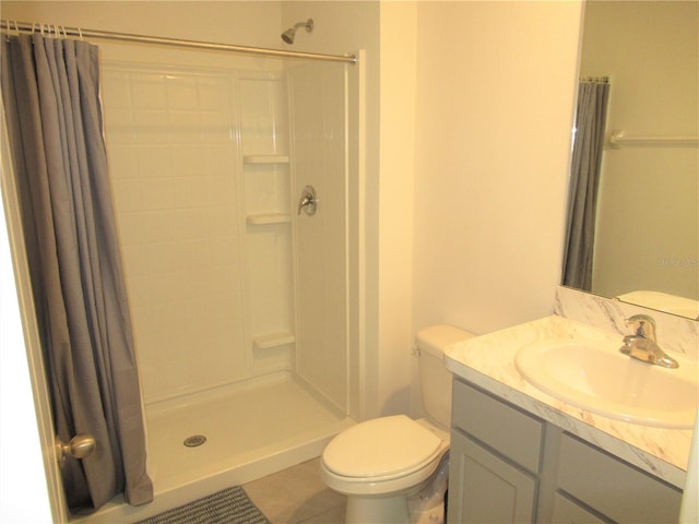 bathroom featuring toilet, a stall shower, tile patterned flooring, and vanity