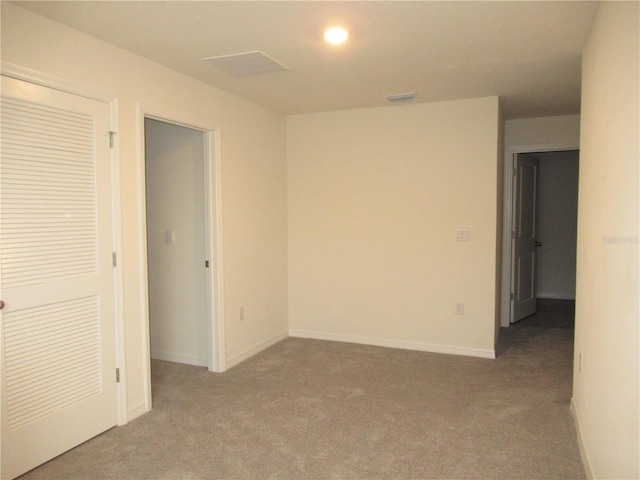 unfurnished room featuring carpet, visible vents, and baseboards