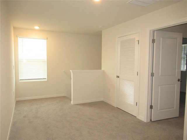 carpeted empty room with visible vents, baseboards, and recessed lighting