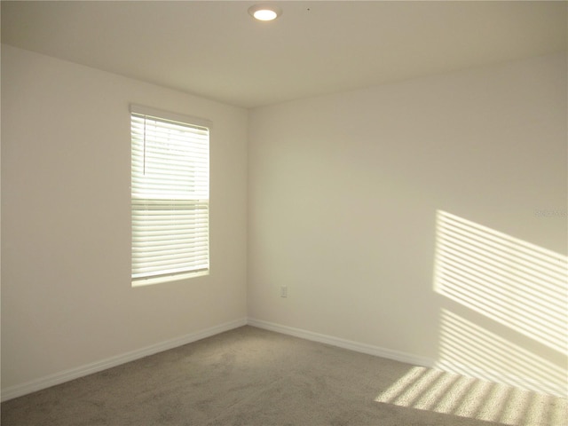 carpeted empty room featuring recessed lighting and baseboards