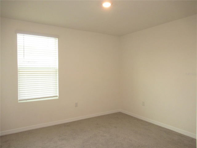 unfurnished room featuring recessed lighting, light carpet, and baseboards