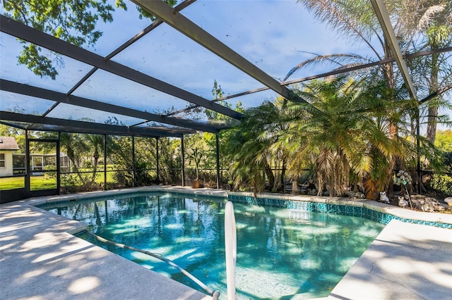 pool with glass enclosure and a patio