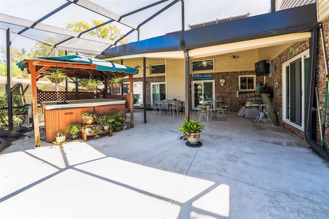 view of patio with a lanai and a hot tub