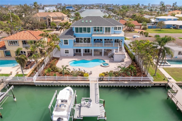 rear view of house featuring a fenced backyard, a patio, a balcony, and a water view