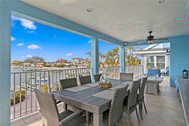 view of patio featuring outdoor dining space, a water view, and ceiling fan