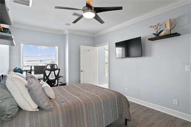 bedroom featuring baseboards, visible vents, crown molding, and wood finished floors