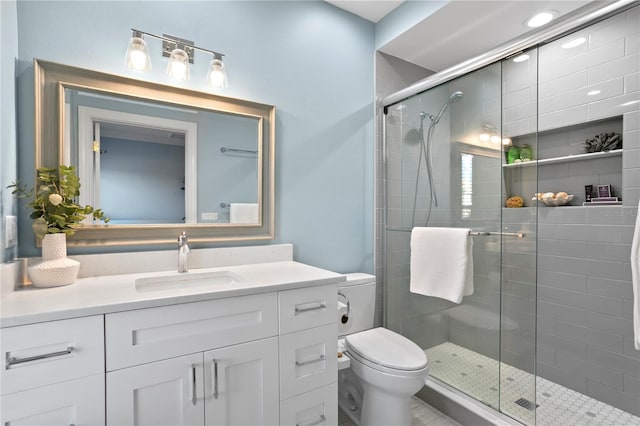 bathroom with a stall shower, vanity, and toilet