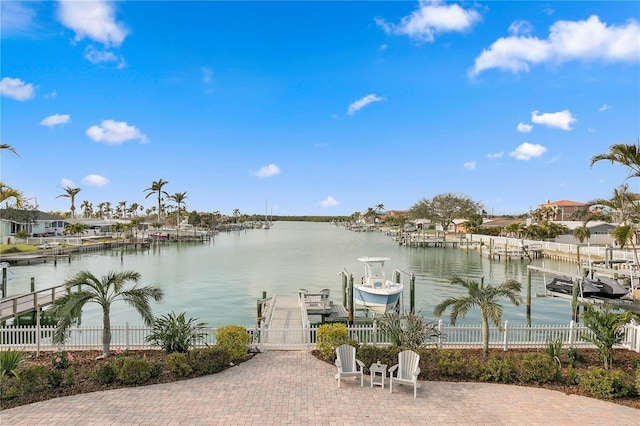 dock area featuring a water view, boat lift, and fence