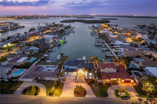 aerial view at dusk featuring a water view