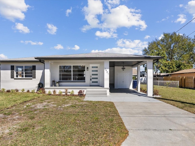 view of front facade with concrete driveway, a front lawn, fence, and stucco siding