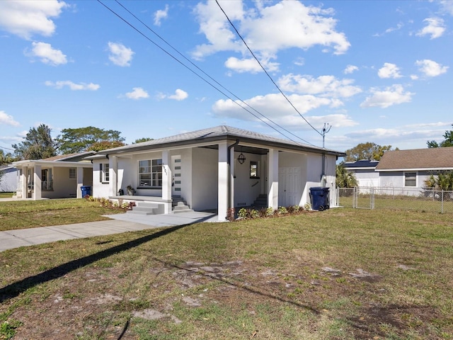 view of front of property featuring fence, a front lawn, and stucco siding