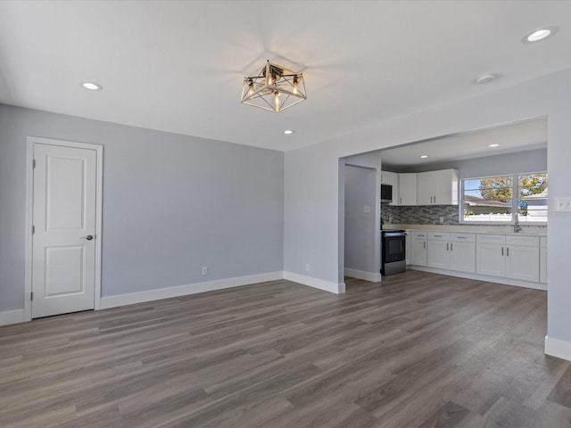 interior space featuring baseboards, wood finished floors, and recessed lighting