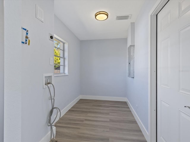 laundry room featuring hookup for a washing machine, visible vents, wood finished floors, laundry area, and baseboards