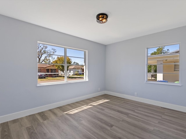 unfurnished room with baseboards and wood finished floors