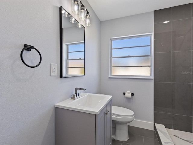 full bathroom with baseboards, tiled shower, toilet, tile patterned flooring, and vanity