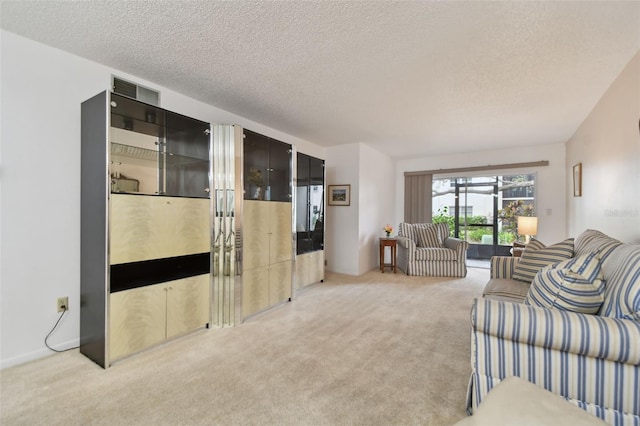 living area featuring light carpet and a textured ceiling