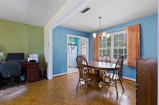 dining room with baseboards, visible vents, a chandelier, and a textured ceiling