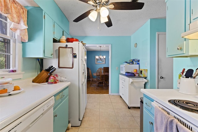 kitchen featuring white appliances, light tile patterned floors, light countertops, a textured ceiling, and blue cabinetry