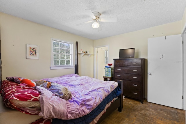 bedroom with a textured ceiling and ceiling fan