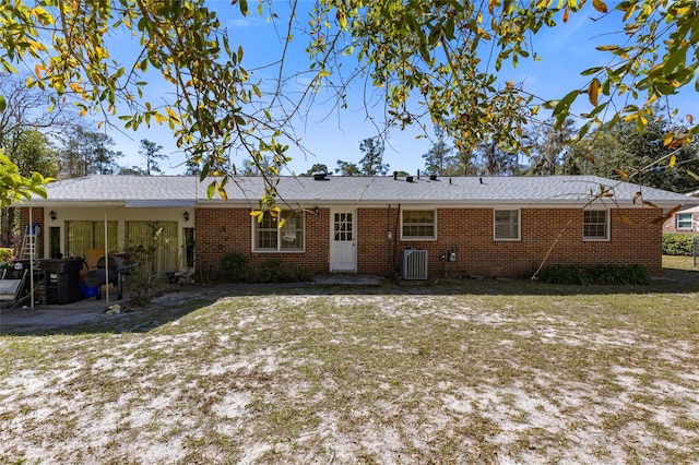 back of house with brick siding and central AC unit