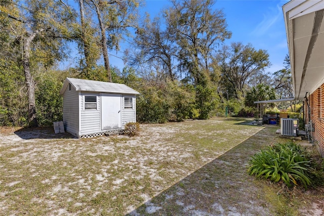 view of yard with central air condition unit, an outdoor structure, and a shed