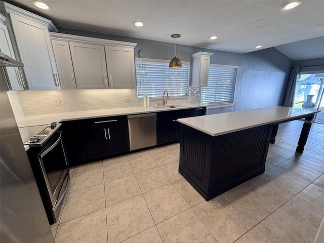 kitchen with a sink, stainless steel appliances, decorative backsplash, and light countertops